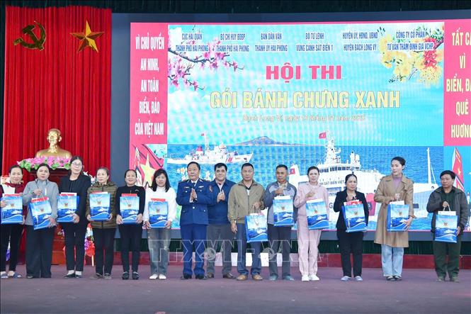 Thiếu tướng Trần Văn Hậu, Chính ủy Vùng CSB 1, tặng quà Tết cho các gia đình có hoàn cảnh khó khăn của huyện đảo Bạch Long Vĩ. Ảnh: TTXVN phát