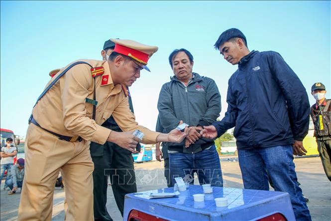 Lực lượng chức năng thử nước tiểu để kiểm tra ma túy đột xuất đối với toàn bộ tài xế xe đưa rước công nhân tại khu công nghiệp Chà Là, huyện Dương Minh Châu, tỉnh Tây Ninh. Ảnh: Giang Phương - TTXVN
