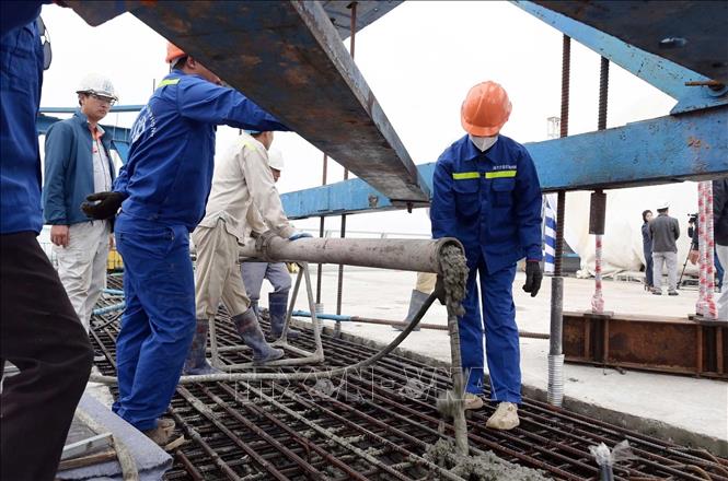 Công nhân tiến hành đổ bê tông hợp long. Ảnh: Thái Thuần - TTXVN

