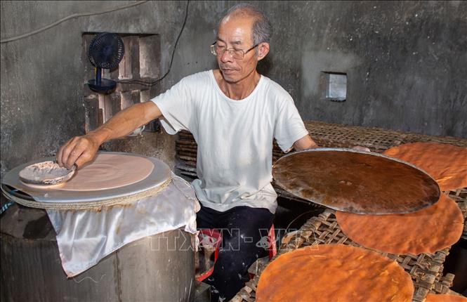 Gia đình ông Nguyễn Văn Goong, xã Khánh Thiện, huyện Yên Khánh, tỉnh Ninh Bình  tăng năng suất làm bánh đa gấc để phục vụ nhu cầu Tết. Ảnh: Hải Yến - TTXVN 