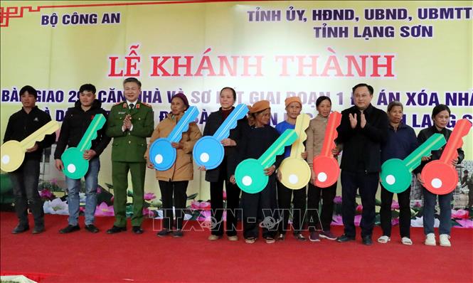 Lãnh đạo Bộ Công an và tỉnh Lạng Sơn trao tượng trưng chìa khóa nhà mới cho người dân huyện Lộc Bình. Ảnh: Văn Đạt - TTXVN