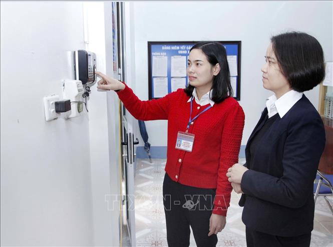 Cán bộ công chức xã Vĩnh Thịnh, huyện Vĩnh Tường thực hiện chắm công. Ảnh: Hoàng Hùng-TTXVN