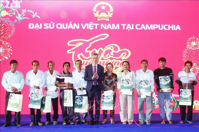 Đại sứ Việt Nam tại Vương quốc Campuchia Nguyễn Minh Vũ (giữa) trao tặng quà Tết cho đại diện các hộ gia đình nghèo và hộ gia đình có công. Ảnh: Hoàng Minh - PV TTXVN tại Campuchia 