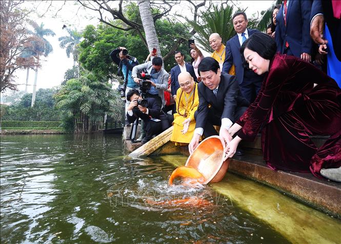 Chủ tịch nước Lương Cường và Phu nhân thả cá chép tiễn ông Công, ông Táo tại Ao cá Bác Hồ trong Khu di tích Phủ Chủ tịch. Ảnh: Lâm Khánh - TTXVN