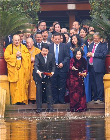 Chủ tịch nước Lương Cường và Phu nhân cho cá ăn tại Ao cá Bác Hồ trong Khu di tích Phủ Chủ tịch. Ảnh: Văn Điệp - TTXVN