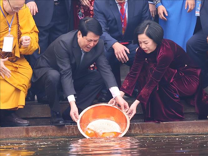 Chủ tịch nước Lương Cường và Phu nhân thả cá chép tiễn ông Công, ông Táo tại Ao cá Bác Hồ trong Khu di tích Phủ Chủ tịch. Ảnh: Văn Điệp - TTXVN
