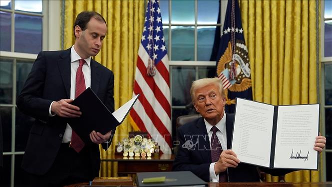 Tổng thống Mỹ Donald Trump (phải) ký sắc lệnh hành pháp ngay sau lễ nhậm chức, tại Nhà Trắng ở Washington DC., ngày 20/1/2025. Ảnh: AP/TTXVN