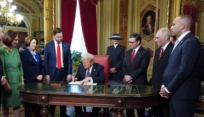 Tổng thống Mỹ Donald Trump (thứ 4, trái) ký sắc lệnh hành pháp ngay sau lễ nhậm chức, tại Nhà Trắng ở Washington DC., ngày 20/1/2025. Ảnh: AP/TTXVN