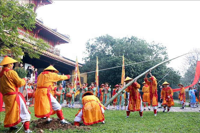 Dựng cây nêu ngày Tết tại di tích Thế Tổ Miếu, nơi thờ các vị Vua nhà Nguyễn. Ảnh: Đỗ Trưởng - TTXVN