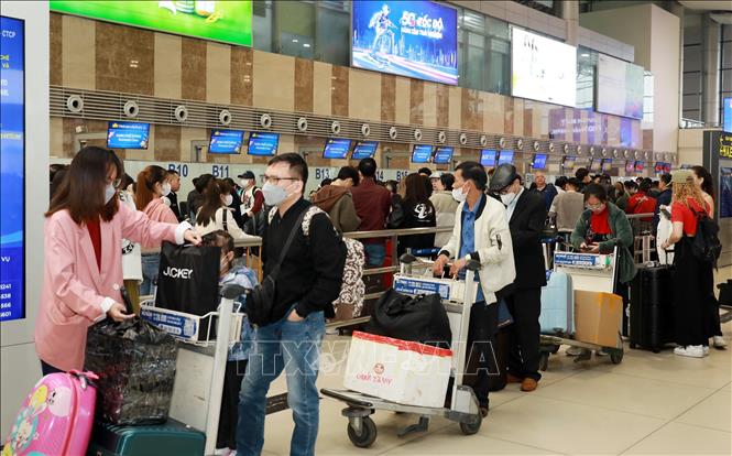 Hành khách xếp hàng chờ làm thủ tục lên máy bay về quê đón Tết tại sân bay quốc tế Nội Bài, sáng 24/1 (25 tháng Chạp). Ảnh: Quốc Khánh - TTXVN