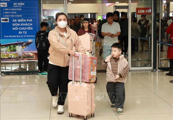 Người dân trở về Hà Nội đón Tết trong sáng 25 tháng Chạp tại sân bay quốc tế Nội Bài. Ảnh: Quốc Khánh - TTXVN