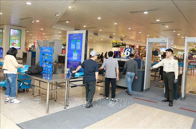 Lực lượng an ninh hàng không hướng dẫn người dân kiểm tra an ninh trước khi vào phòng chờ lên máy bay. Ảnh: Quốc Khánh - TTXVN