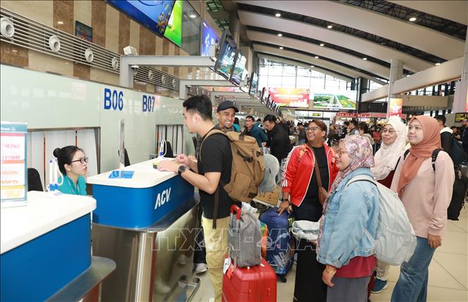 Passengers line up at a check-in gate at Noi Bai International Airport. VNA Photo: Quốc Khánh