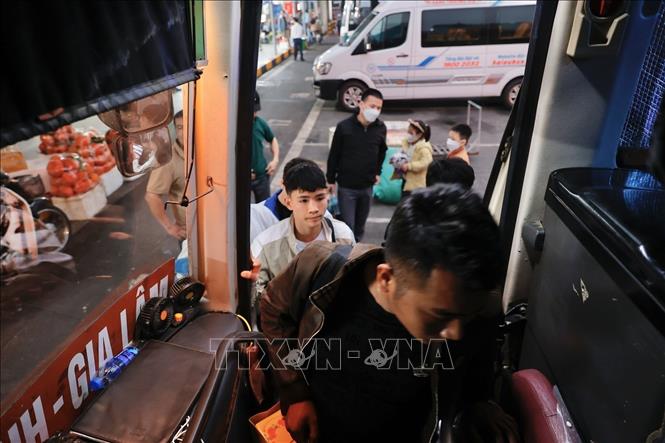 Khách lên xe về quê đón tết tại bến xe Gia Lâm. Ảnh: Minh Quyết - TTXVN