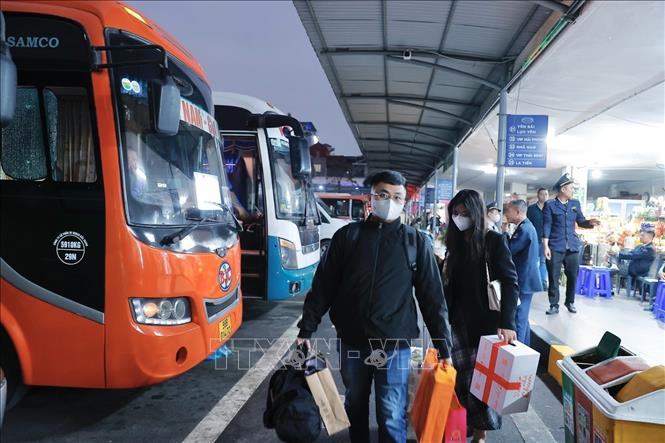 Hành khách lên xe về quê đón Tết tại bến xe Gia Lâm. Ảnh: Minh Quyết - TTXVN