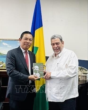 Đại sứ Vũ Trung Mỹ tặng Thủ tướng ông Ralph Gonsalves cuốn sách về Chủ tịch Hồ Chí Minh. Ảnh: ĐSQ cung cấp/TTXVN phát