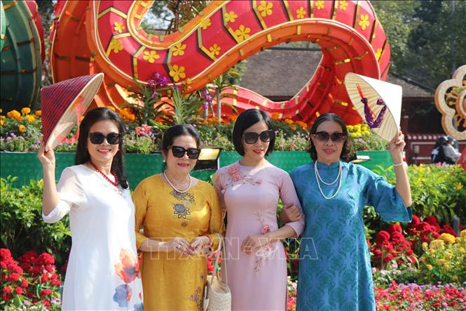Phụ nữ Huế trong tà áo dài truyền thống, lưu giữ hình ảnh đẹp trước thềm năm mới. Ảnh: Mai Trang - TTXVN 