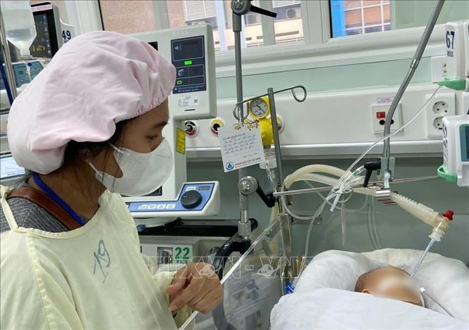 Thân nhân bệnh nhi mang lời ước nguyện treo đầu giường  con trong những ngày cuối năm. Ảnh: TTXVN phát