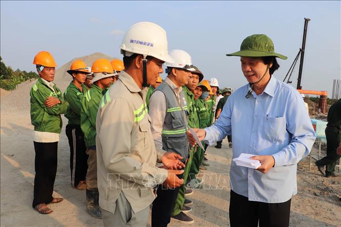 Bí thư Tỉnh ủy Tiền Giang Nguyễn Văn Danh (thứ 2 từ trái sang) tặng quà, chúc Tết công nhân các đơn vị thi công trên công trường. Ảnh: Minh Trí - TTXVN