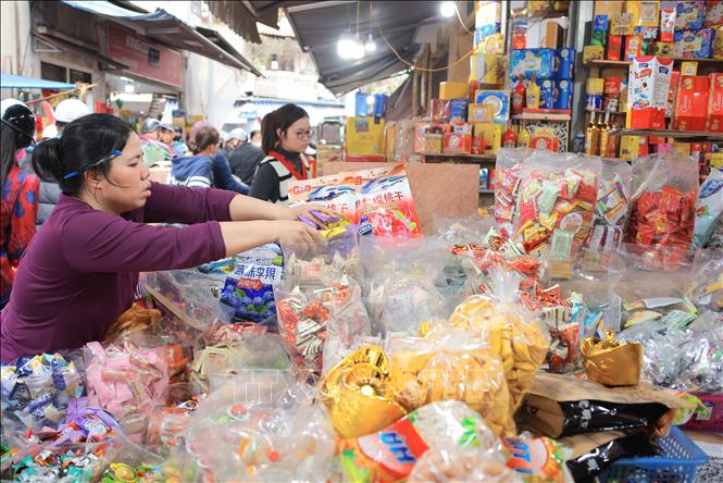 Các tiểu thương đã chuẩn bị đa dạng các mặt hàng bánh mứt kẹo, để phục vụ nhu cầu mua sắm tăng cao của người dân. Ảnh: Hoàng Hiếu - TTXVN