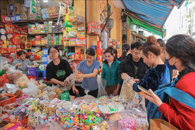 Nhiều người dân tìm đến khu vực phố Hàng Giầy để tìm mua các loại bánh kẹo phù hợp, chuẩn bị cho một cái Tết đủ đầy, ấm áp. Ảnh: Hoàng Hiếu - TTXVN