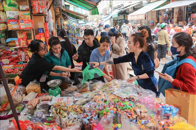 Nhiều người dân tìm đến khu vực phố Hàng Giầy để tìm mua các loại bánh kẹo phù hợp, chuẩn bị cho một cái Tết đủ đầy, ấm áp. Ảnh: Hoàng Hiếu - TTXVN