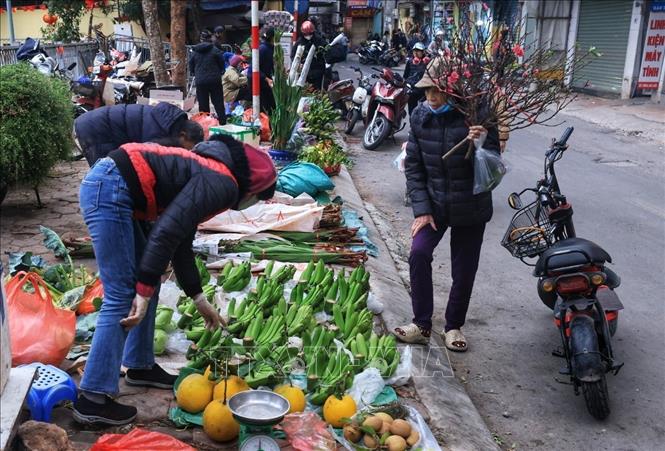 Người dân đi chợ lựa chọn những món đồ cho mâm ngũ quả ngày Tết. Ảnh: Tuấn Anh  - TTXVN 