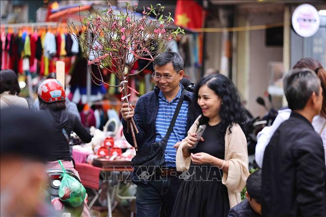 For many residents of Hanoi, visiting the market during the days leading up to Tet is an opportunity to immerse themselves in the sights and smells of the season. VNA Photo: Minh Đức