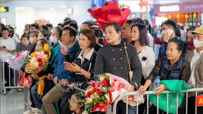 Đợi đón người thân từ nước ngoài trở về tại Sân bay quốc tế Nội Bài, sáng 27/1. Ảnh: TTXVN