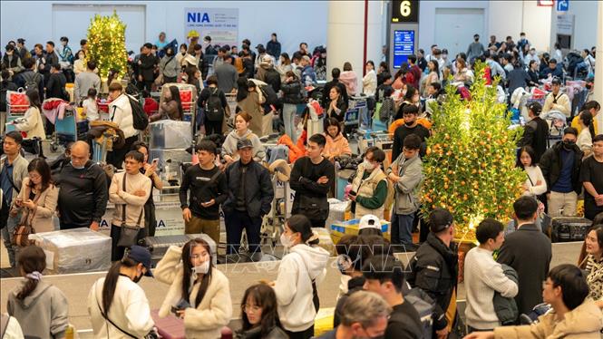 Hành khách đợi lấy hành lý tại Sân bay quốc tế Nội Bài, sáng 27/1. Ảnh: TTXVN