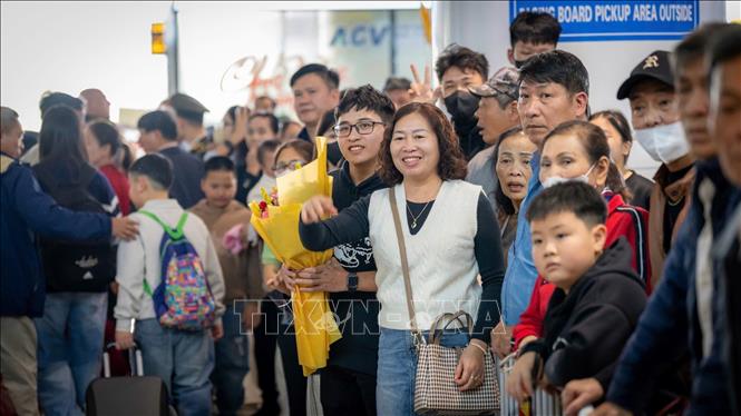Người thân đến đón hành khách từ nước ngoài trở về Việt Nam ăn Tết tại nhà ga T2, Sân bay quốc tế Nội Bài, sáng 27/1. Ảnh: TTXVN