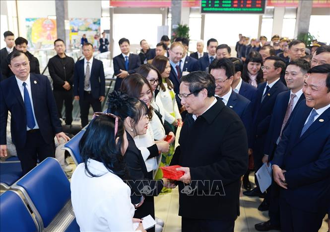 Thủ tướng Phạm Minh Chính chúc Tết, tặng lì xì cho hành khách tại ga tàu Hà Nội. Ảnh: Dương Giang-TTXVN 