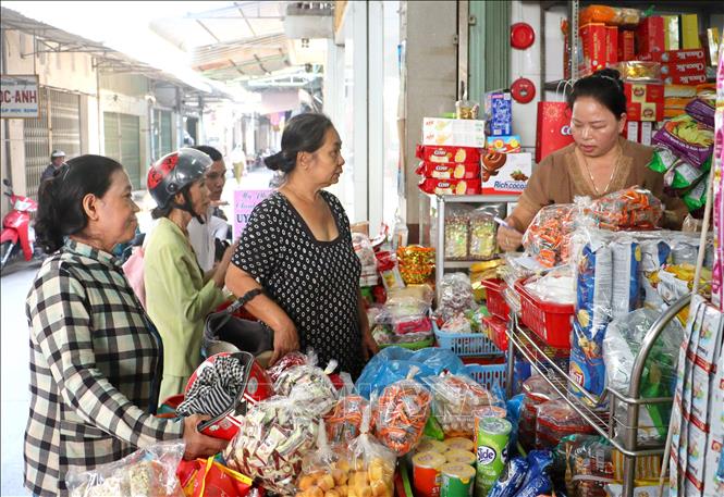 Các hộ nghèo, khó khăn xã Tân An Thạnh, huyện Bình Tân, tỉnh Vĩnh Long mua hàng trong Phiên chợ Tết nhân ái. Ảnh: Lê Thúy Hằng - TTXVN