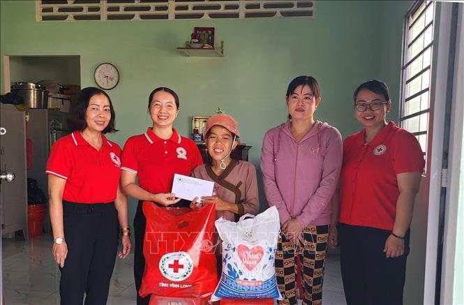 Hội Chữ Thập đỏ tỉnh Vĩnh Long đến thăm và trao quà Tết cho gia đình chị Trần Thị Hương, ngụ phường 5, thành phố Vĩnh Long (ở giữa). Ảnh: Lê Thúy Hằng - TTXVN