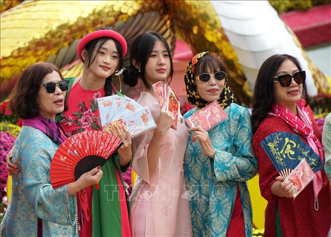 Young people visit Bach Dang walking street to take Tet photos. VNA Photo: Quốc Dũng