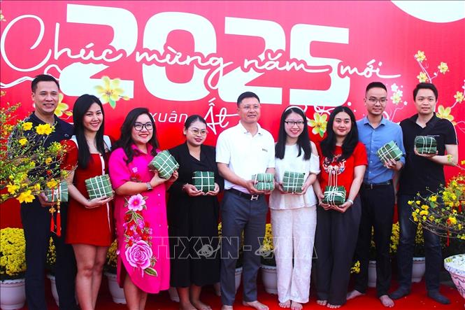 Tập thể cán bộ nhân viên Metfone quây quần bên những cành mai, đóa cúc vàng, bánh chưng xanh, rộn ràng đón Tết cổ truyền. Ảnh: Quang Anh – PV TTXVN tại Campuchia