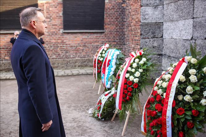 Tổng thống Ba Lan Andrzej Duda đặt hoa tại Bức tường Tử thần của trại tập trung Auschwitz trong buổi lễ. Ảnh: PAP/TTXVN