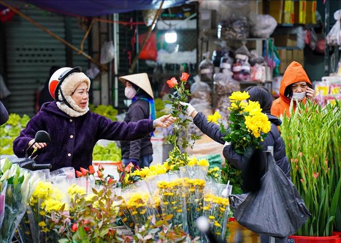 Người dân mua sắm, chuẩn bị những đồ cần thiết cho mâm cúng tất niên. Ảnh: Khánh Hoà - TTXVN