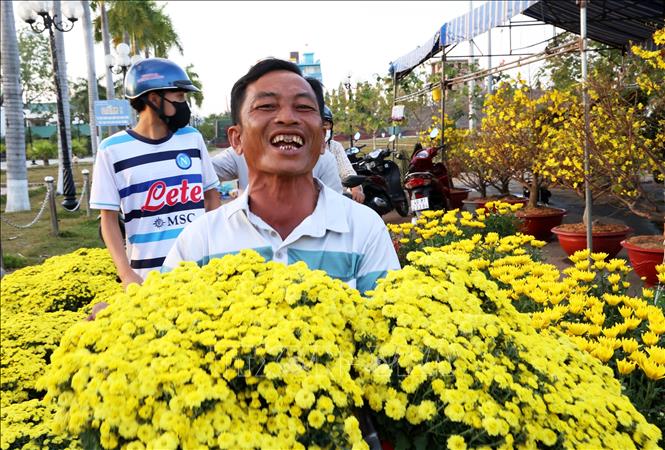 Anh Trần Văn Thắng, thôn 8, thị trấn Đạ Tẻh (Đạ Huoai, Lâm Đồng), vui mừng khi bán được 2 chậu cúc mâm xôi trong chiều cuối năm. Ảnh: Hồng Đạt - TTXVN
