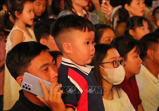 Trẻ nhỏ cùng người lớn xem bắn pháo hoa chào mừng năm mới tại vùng sông nước Ngã Năm. Ảnh: Tuấn Phi – TTXVN 