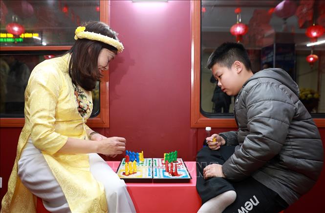 Du khách tham gia chơi trò chơi dân gian trên toa cộng đồng trong đêm Giao thừa. Ảnh: Quốc Khánh - TTXVN