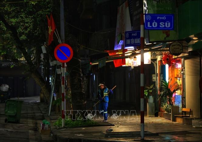 Một công nhân vệ sinh làm việc sáng mùng 1 tết. Ảnh: Tuấn Anh  - TTXVN 