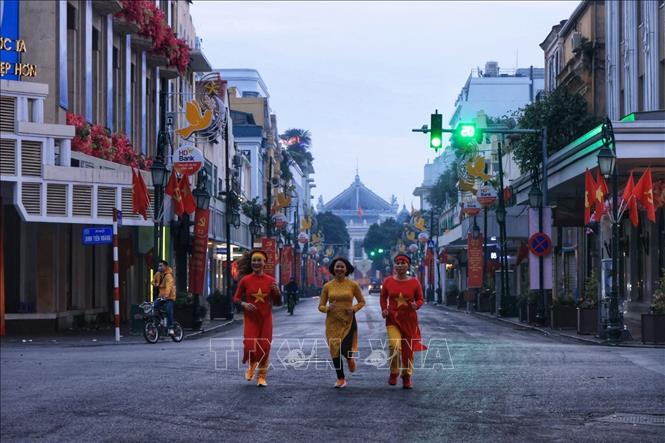 Nhiều chị em thướt tha áo dài sáng sớm mùng 1 tết. Ảnh: Tuấn Anh  - TTXVN 