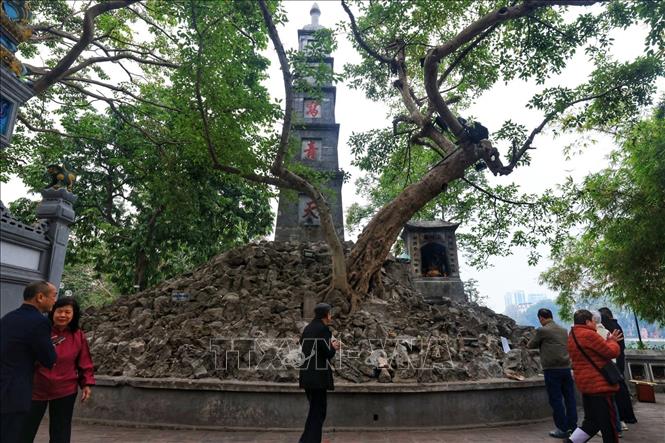 Sáng sớm mùng 1 Tết, nhiều người đến lễ cầu may tại Tháp Bút bên hồ Hoàn Kiếm. Ảnh: Tuấn Anh  - TTXVN 