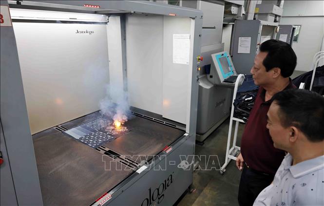 Công ty TNHH Việt Thắng Jean đã đầu tư máy laser dùng cho in trên vải thay cho sử dụng hóa chất như trước đây. Ảnh: Trần Việt - TTXVN
