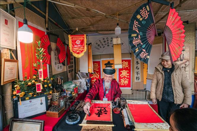 Một ông đồ cho chữ tại khu vực hồ Văn (Văn Miếu - Quốc Tử Giám). Ảnh: Phạm Tuấn Anh - TTXVN