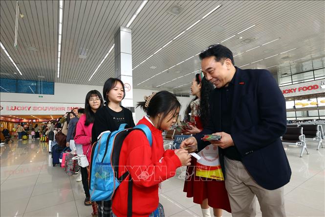 Lãnh đạo Hãng Hàng không Vietjet Air mừng tuổi cho khách đi máy bay. Ảnh: Huy Hùng - TTXVN