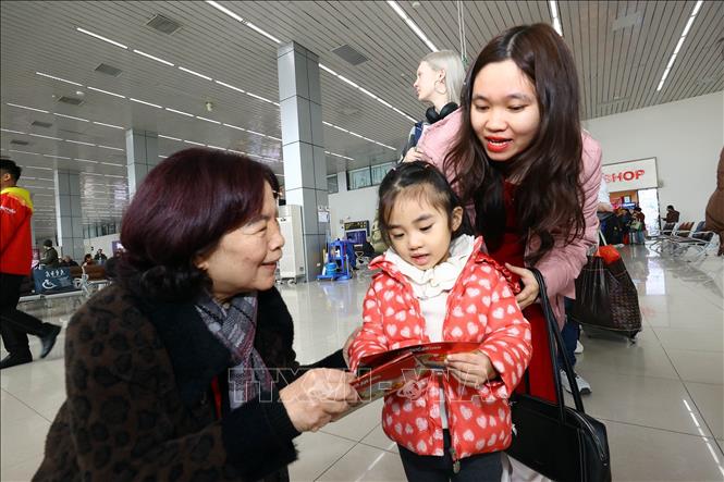 Lãnh đạo hãng Hàng không Vietjet Air tặng mừng tuổi cho khách đi máy bay. Ảnh: Huy Hùng - TTXVN