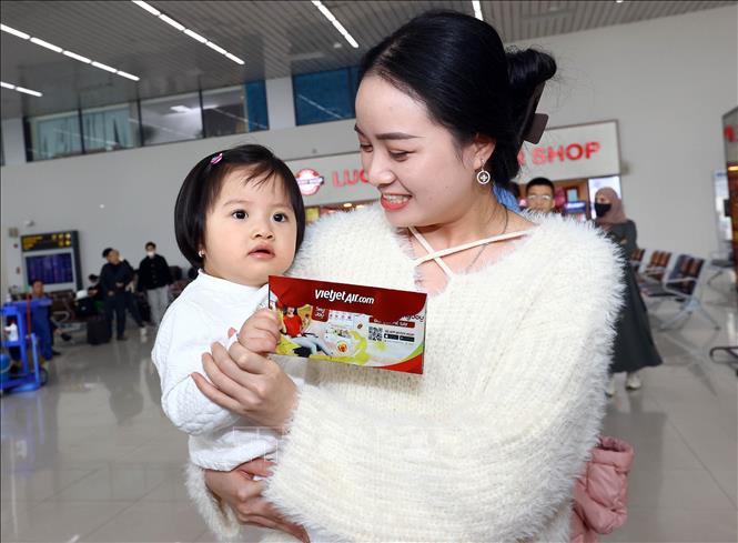 Niềm vui của hành khách khi nhận tiền mừng tuổi may mắn trong ngày đầu năm. Ảnh: Huy Hùng - TTXVN