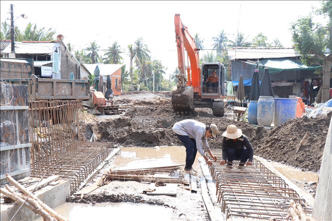 Xây dựng đê bao chống ngập, ngăn mặn, trữ ngọt kết hợp với giao thông trên địa bàn xã Hưng Phong.Ảnh: Công Trí-TTXVN